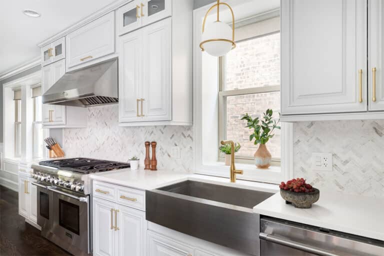 Resurfaced white kitchen cabinets with gold hardware